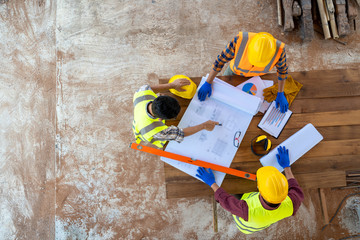 High angle view of engineer and architect discussing building plan at construction site,Group of...