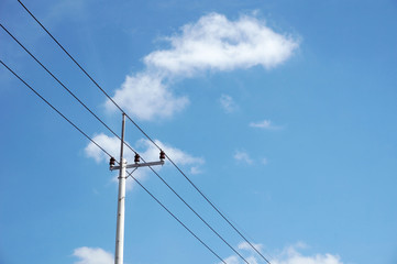 Obraz premium Electric pole power lines outgoing electric wires againts on cloud blue sky. 