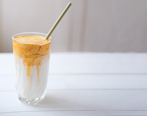 Iced frothy Dalgona Coffee, a trendy fluffy creamy whipped coffee. Korean drink latte espresso with coffee foam. made of instant coffee, sugar, hot water and milk. 