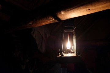 Traditional kerosene lamp hung under a wooden beam in shepherd's  hut in mountains