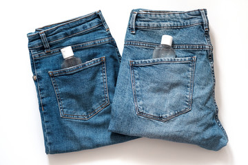 Small portable antibacterial hand sanitizer in pocket jeans. Take healthcare items with you,disinfect and wash your hands. Prevent the spread of germs and bacteria and avoid infections coronavirus.