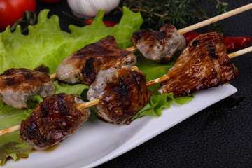 Pork kebab skewers in the plate with salad leaves and tomatoes