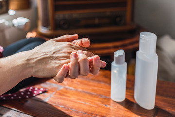 A Woman cleans and sanitizes her hands at home with Covid-19.