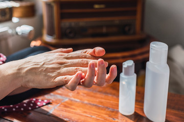 A Woman cleans and sanitizes her hands at home with Covid-19.