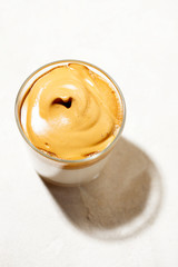 Trendy fluffy creamy whipped iced Dalgona coffee on white background.Korean drink latte espresso...