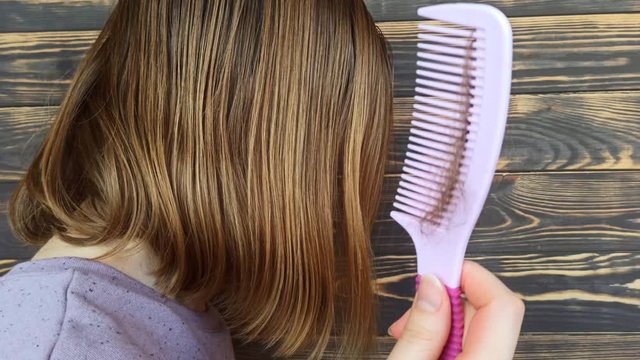 Hair loss problem. Woman is holding with pink comb. 