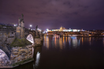 Fototapeta na wymiar night landscape on Charles bridge in Prague, sculptures and the old town