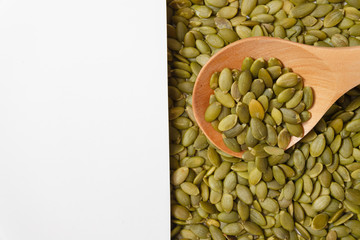 Peeled Pumpkin Seeds. Unshelled kernels. Nuts lie in a wooden spoon.