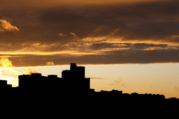 Fototapeta premium Dark city contrasts in the evening orange sky.