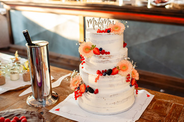 four-tier wedding cake decorated with fresh flowers and fruits