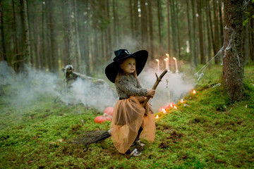 Fototapeta premium little girl witch on a broomstick for halloween