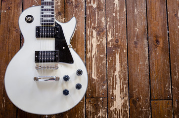 Vintage white electric guitar on a hardwood floor