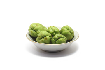 A group of bitter melons/bitter gourds (Momordica charantia) on a small plate isolated on white background