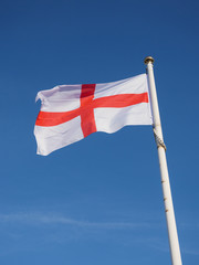English St George Cross flag aloft against a blue sky. England.