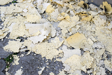 Facade debris on paving slabs. Torn off quartz soil from the wall.