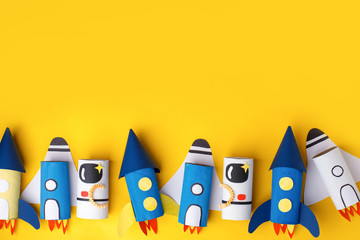 School kindergarten crafts, paper spaceship, shuttle, astronaut on yellow background with copy...