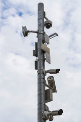 A group of surveillance cameras on a gray sky background.