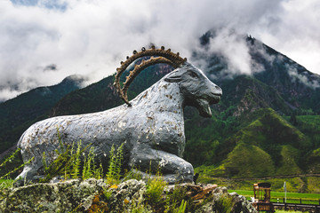 Statue of a mountain goat on the background of mountain range in the Ongudaysky district of the...