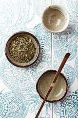 Dried Green Tea Leaves on Bright Background. Top view. 