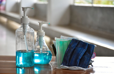 Hand sanitizer gel and facemasks in front of the office's doors for the officers to clean hands and wear before getting inside to protect and prevent Covid-19 virus or Coronavirus and germs.