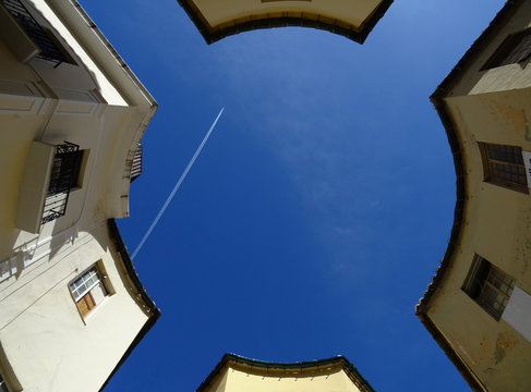 Silhouette looking the sky formed by circular square in Passageway of Chinitas. City of Malaga. Andalusia. Spain.  