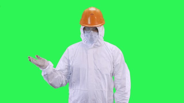 A man in a helmet and protective suit suggests making a choice.Green screen background.