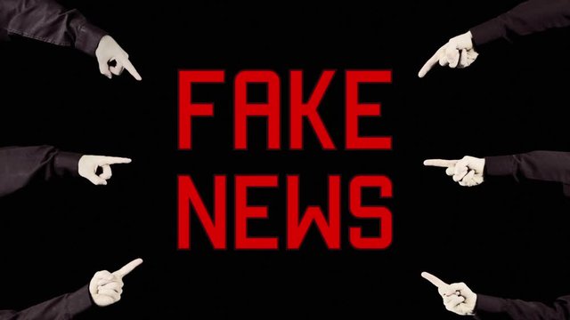 Many hands pointing at a warning message text, appearing and disappearing with a dissolve effect: Fake News.
