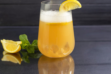 Fresh homemade ginger beer cocktail. Ice and lime on the table. On a black background. Copy space