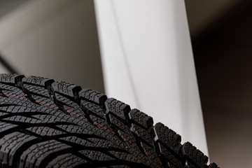 Stack of brand new high performance car tires on clean high-key white studio background. new car tire background. close up of texture