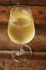 A glass of white wine on a wooden table