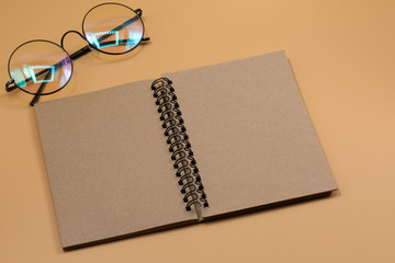 notebook is open with eyeglasses on office desk