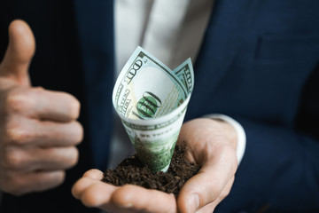 100 dollars growing money in businessman hands. Investment And Interest Concept. businessman protects growing investments.