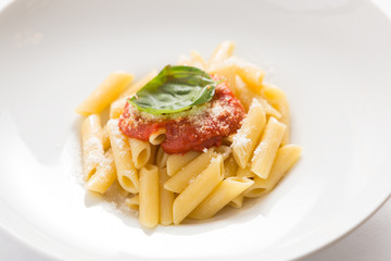 Tomato pasta, typical dish of the Italian tradition. Bronze-drawn Gragnano macaroni with San Marzano tomato, basil and extra virgin olive oil