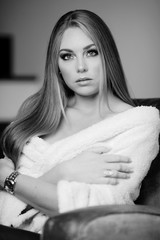 Portrait d'une jolie jeune femme blonde couverte d'un plaid et se reposant chez elle