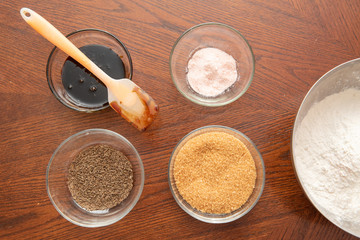 Top view Ingredients for making homemade baking. Caraway seeds, flour, sugar, salt in glass bowls. home kitchen