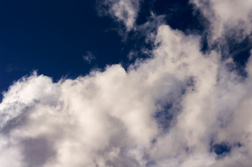 Thick clouds in the blue sky. Background photo of clouds where the sun shines through.