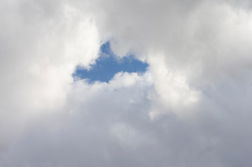 Thick clouds in the blue sky. Background photo of clouds where the sun shines through.