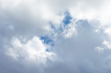 Thick clouds in the blue sky. Background photo of clouds where the sun shines through.