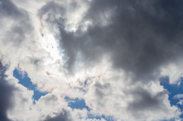 Thick clouds in the blue sky. Background photo of clouds where the sun shines through.