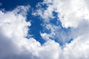 Thick clouds in the blue sky. Background photo of clouds where the sun shines through.
