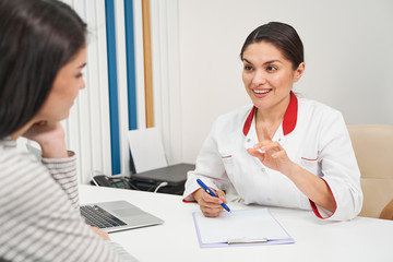 Fototapeta premium Miła młoda kobieta rozmawia ze swoim pacjentem