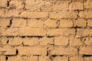 Yellow painted old brick wall abstract backgound