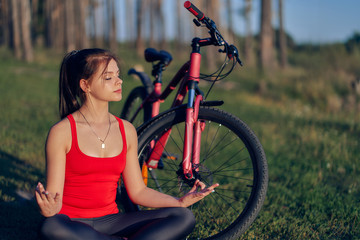 Girl sitting on the grass in lotus position.