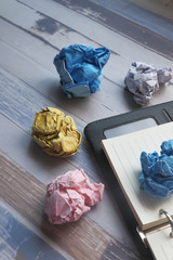 crumpled paper ball and notepad color background.