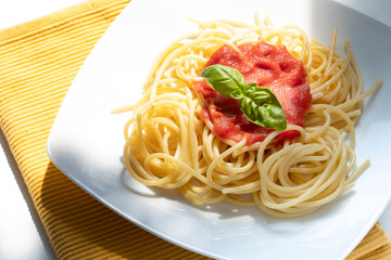 dish with spaghetti and tomato sauce on the white table