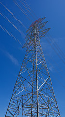 High voltage electrical tower. Electric poles in front of blue sky.