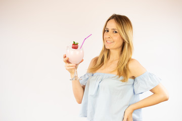 Beautiful woman drinking a strawberry smoothie