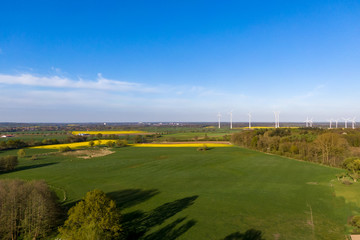 Vogelperspektive Blick über Wiesen, Felder und Wälder auf Windräder