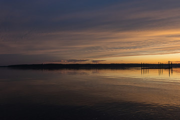 Naklejka premium sun setting over a long fishing dock