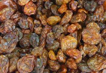 Raisins as abstract background texture, dark and colored, closeup top view
